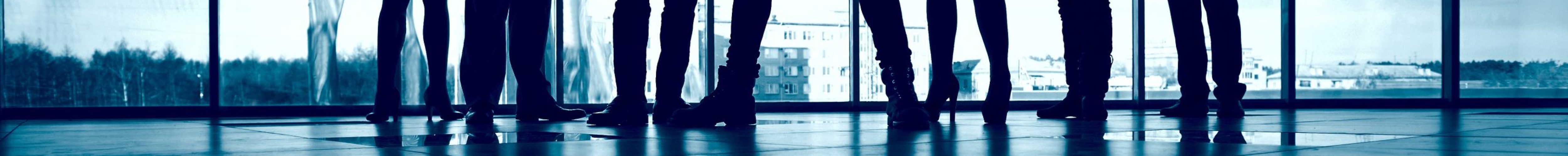 Business team standing against window with leader in front